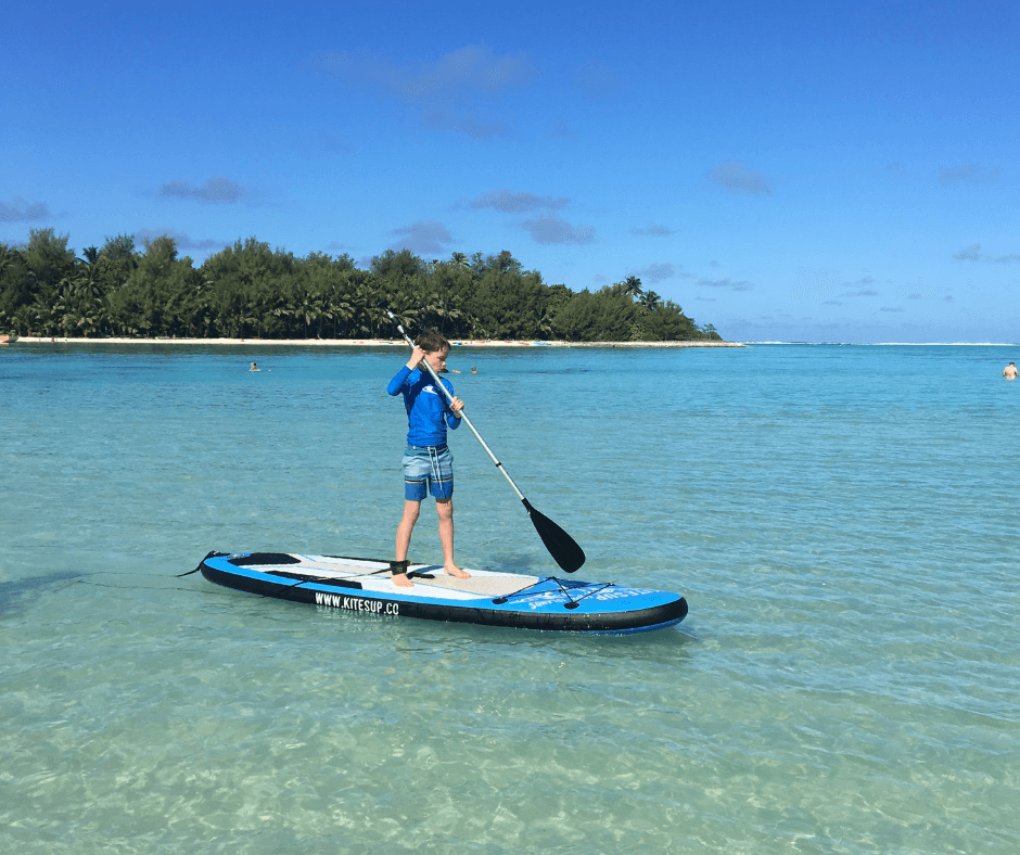 Lukas paddleboarding for his first time on Muri lagoon, Rarotonga