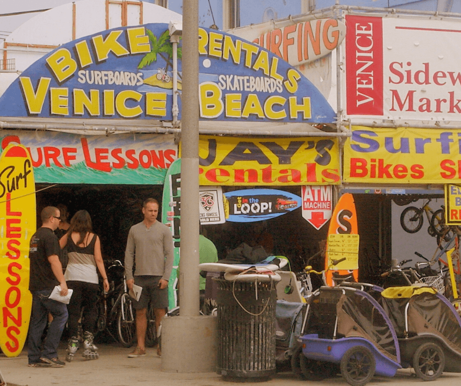 Looking at the store front of Jay's rental with people wandering in