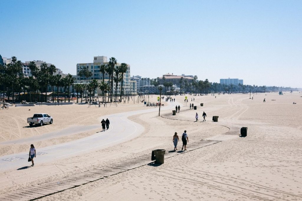 Sunny day looking down the beach, plenty of people walking