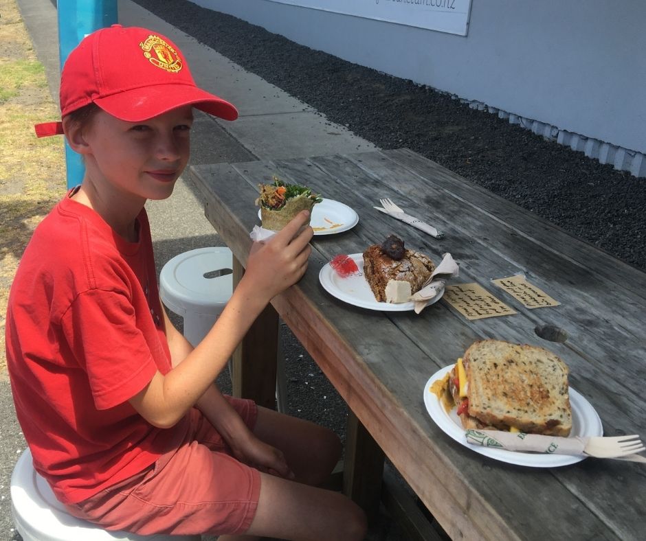 Lukas eating at Gratitude Wholefood Eatery one of the best Mount Maunganui cafes