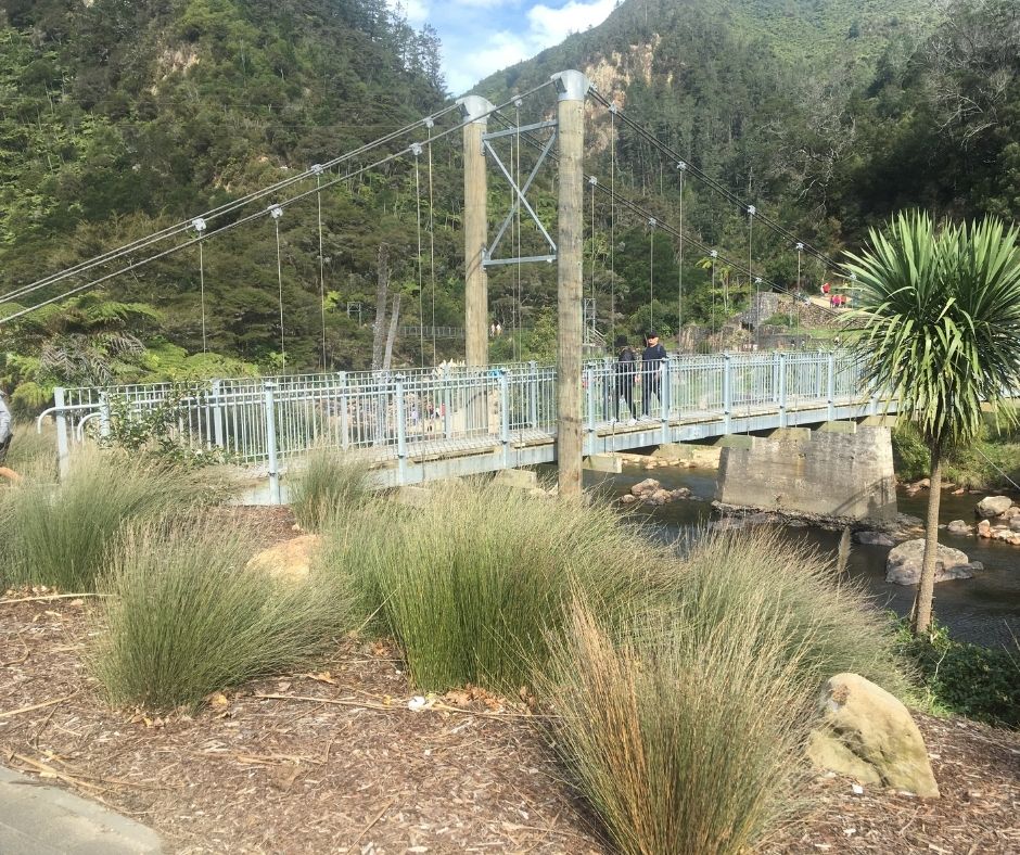 A couple walking across the first footbridge in Karangahake Gorge