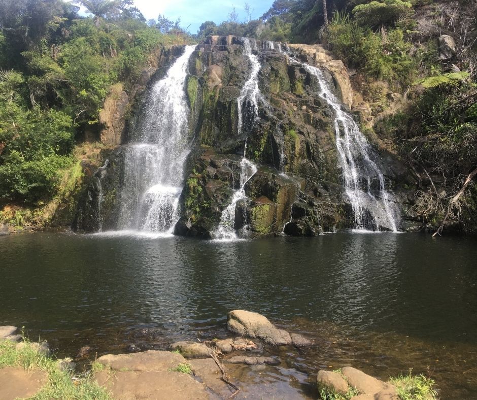 Water flowing down the Owharoa Falls and into the water below