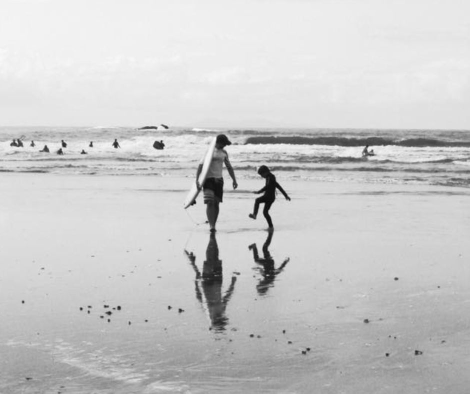 Dad and Lukas walking out of the sea after another one of Lukas's Mount Maunganui surf lessons