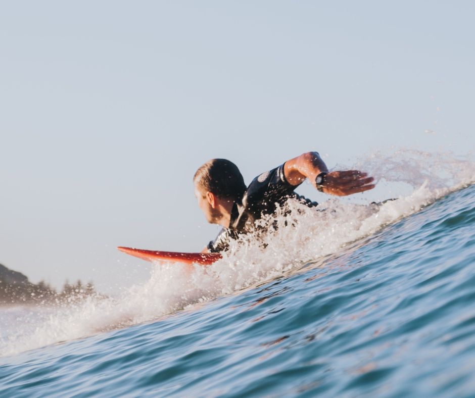 Surfer about to pop up and catch a wave