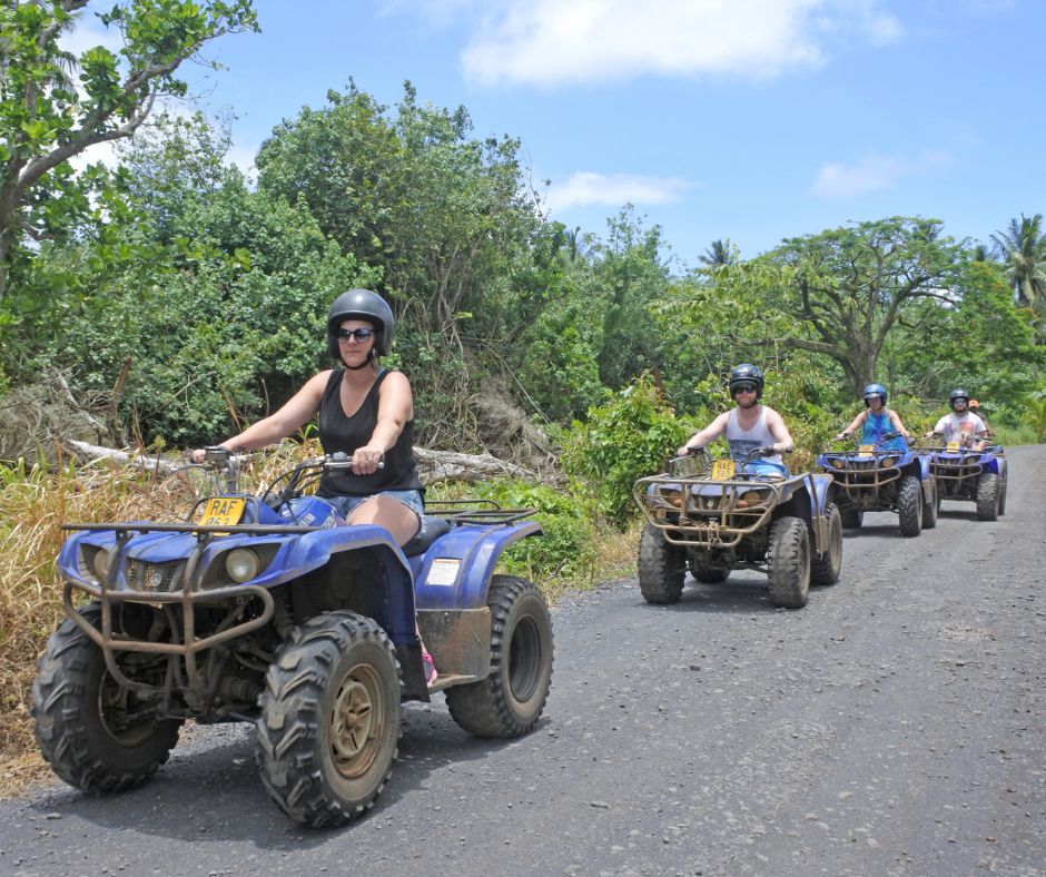 Four quad bikes lining up on the back roads of Rarotonga