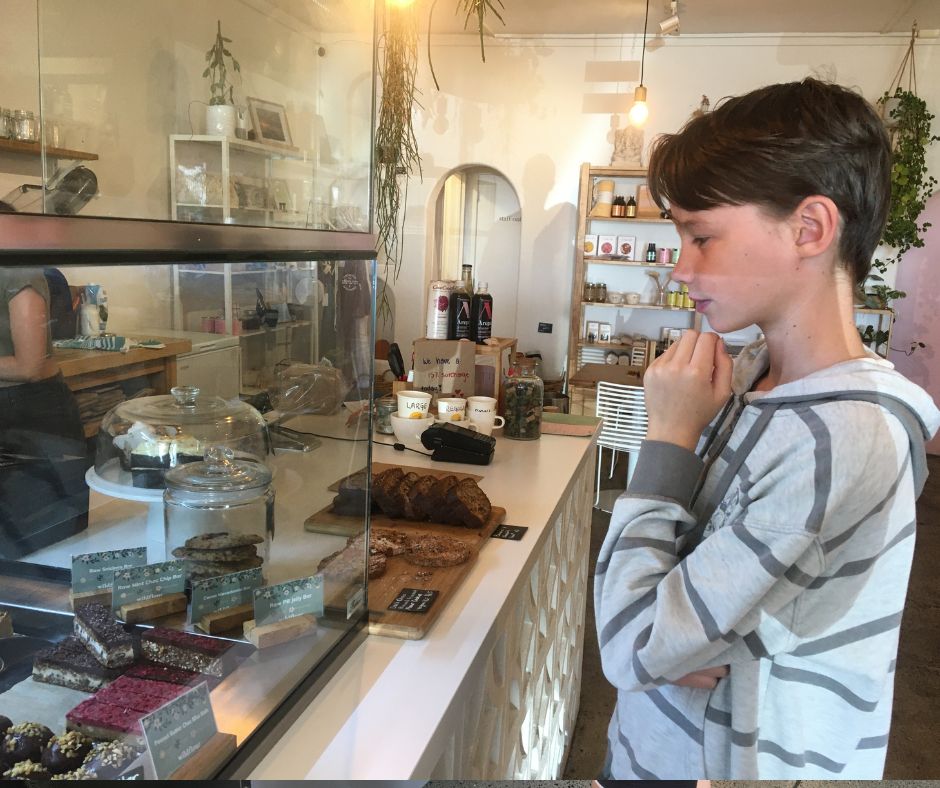 Lukas standing in front of the food cabinet thinking about which slice to pick