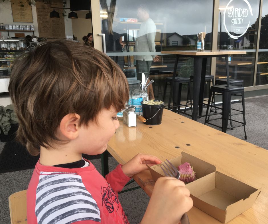 Sawyer eating the slice outside the cafe