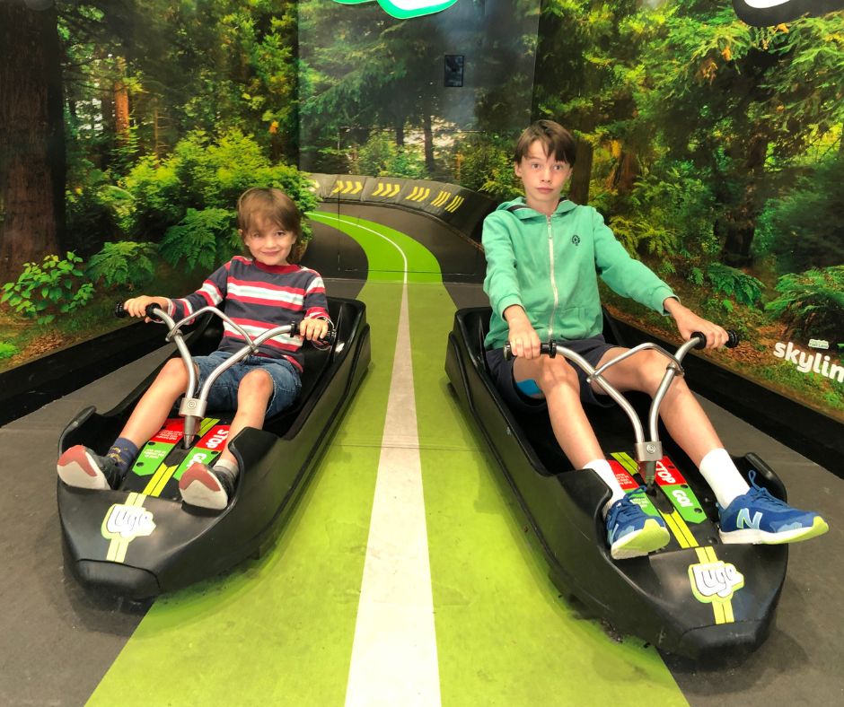 Lukas and Sawyer getting a photo on the luge display at the Skyline ticket office