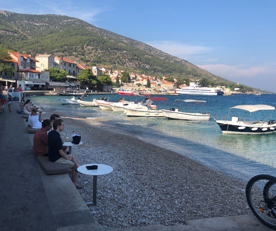 People sitting on Bol's waterfront with a drink in their hands