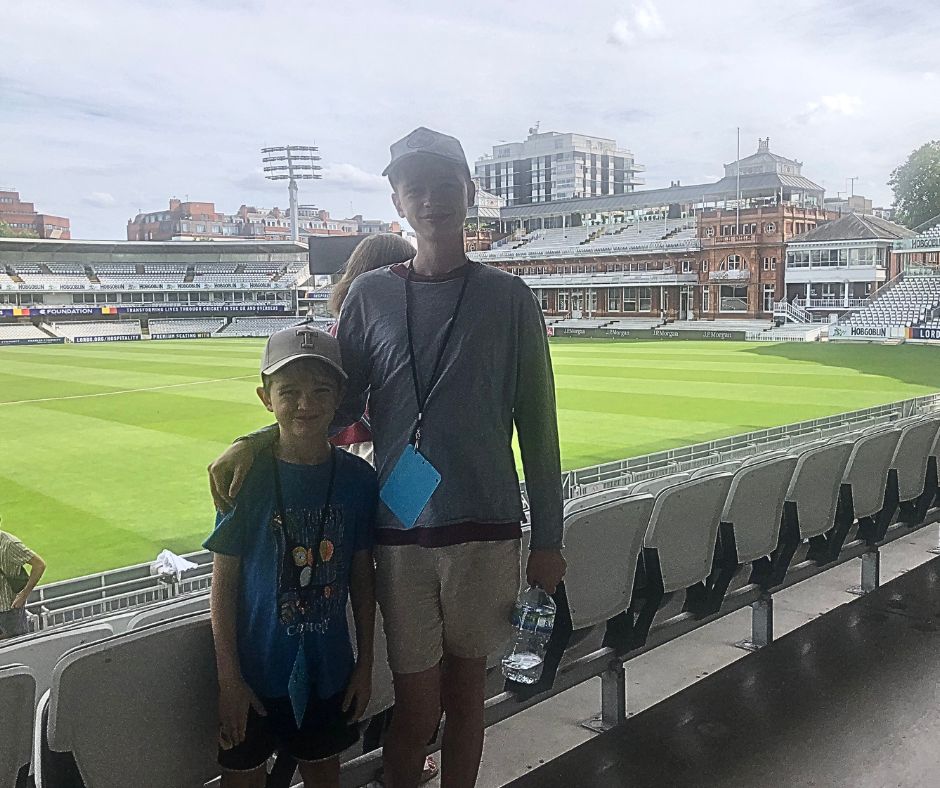 Sawyer and Lukas posing for a photo in the stands with the Lords out field as the back drop