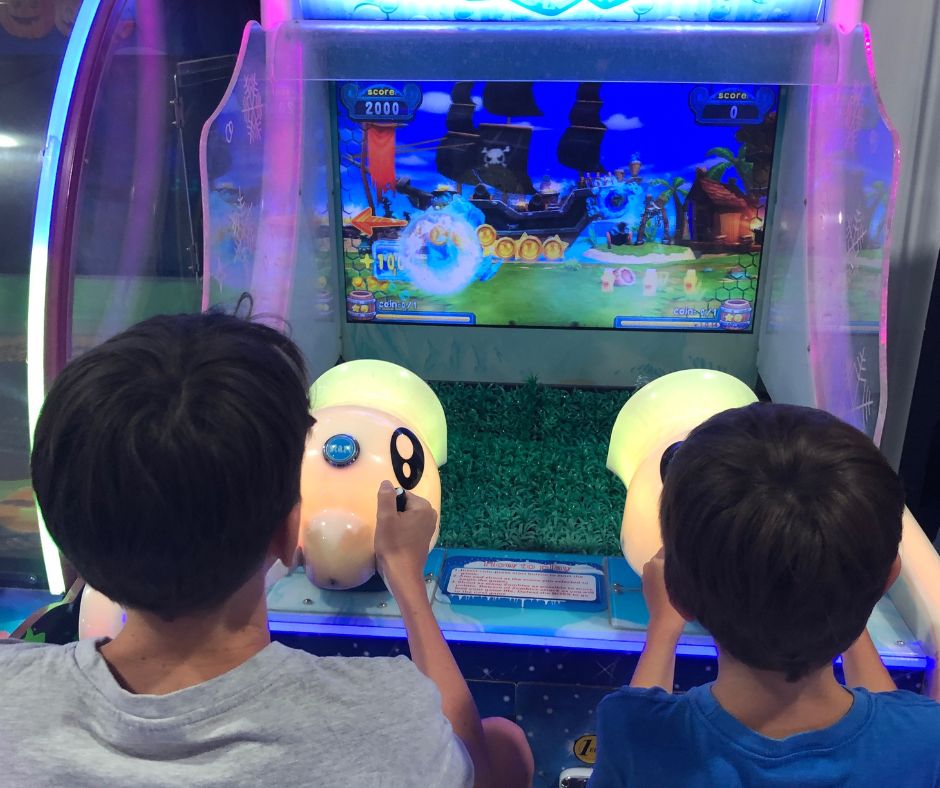 Boys playing video games together in Budva's amusement parks