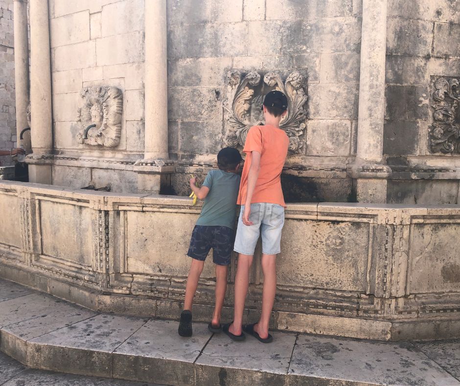 Lukas ans Sawyer filling their water bottles at Onofrio's fountain