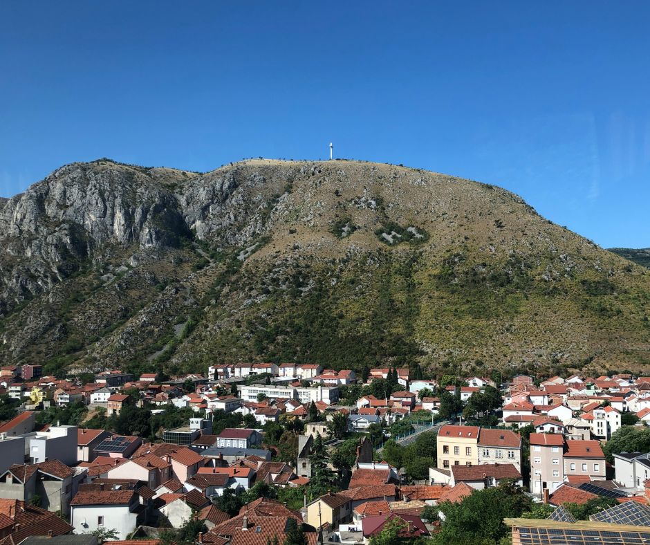 Looking at Hum Hill with a white cross at the top from Stari Most