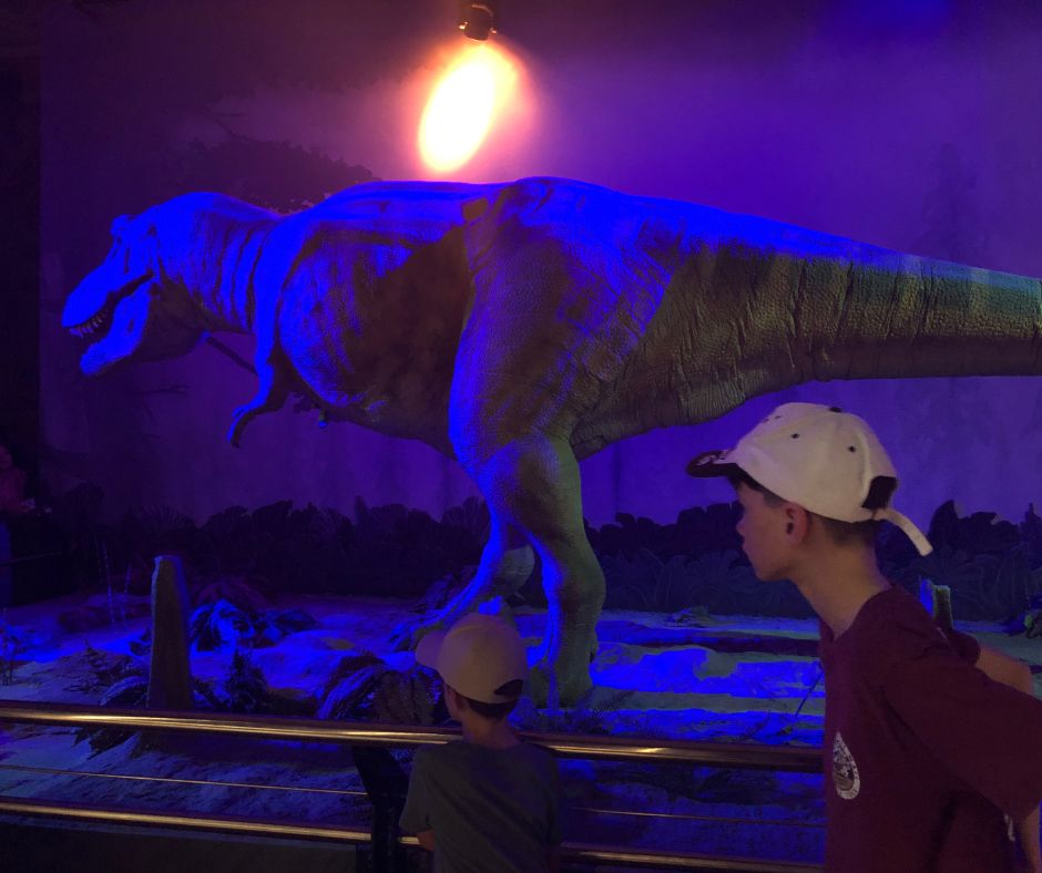 Sawyer posing for a photo with a T-Rex