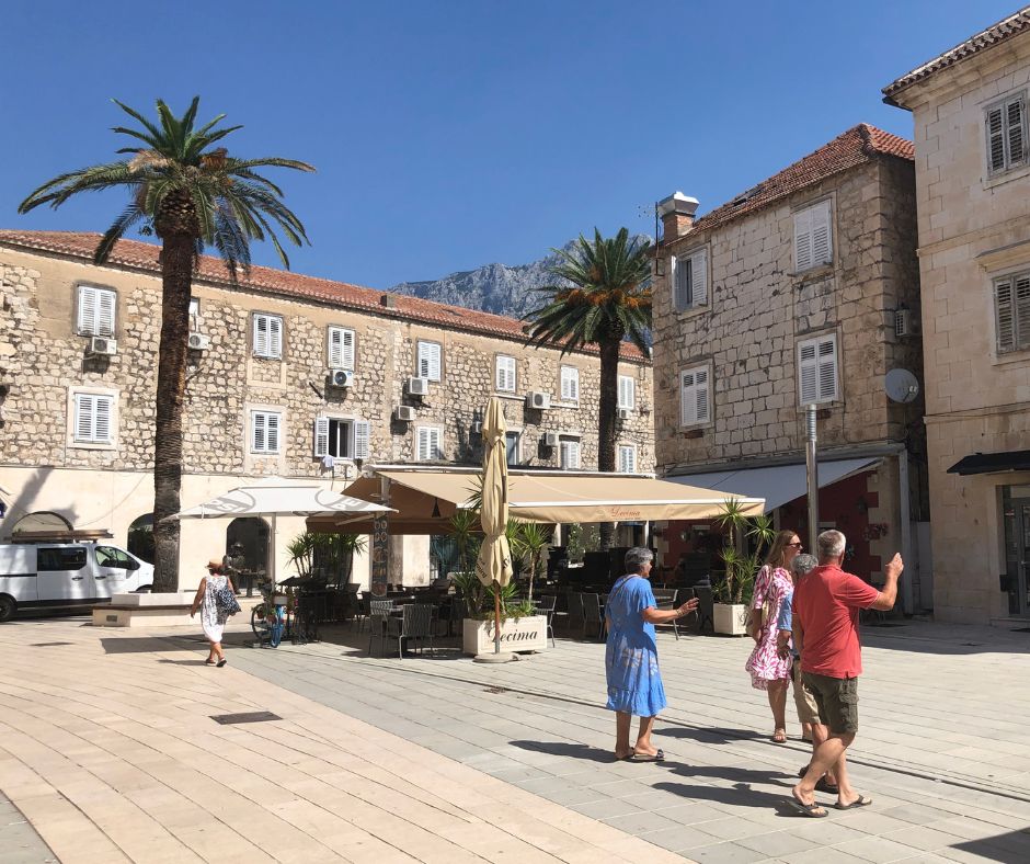 One of Makarska's old town squares, with stunning buildings and a cafe