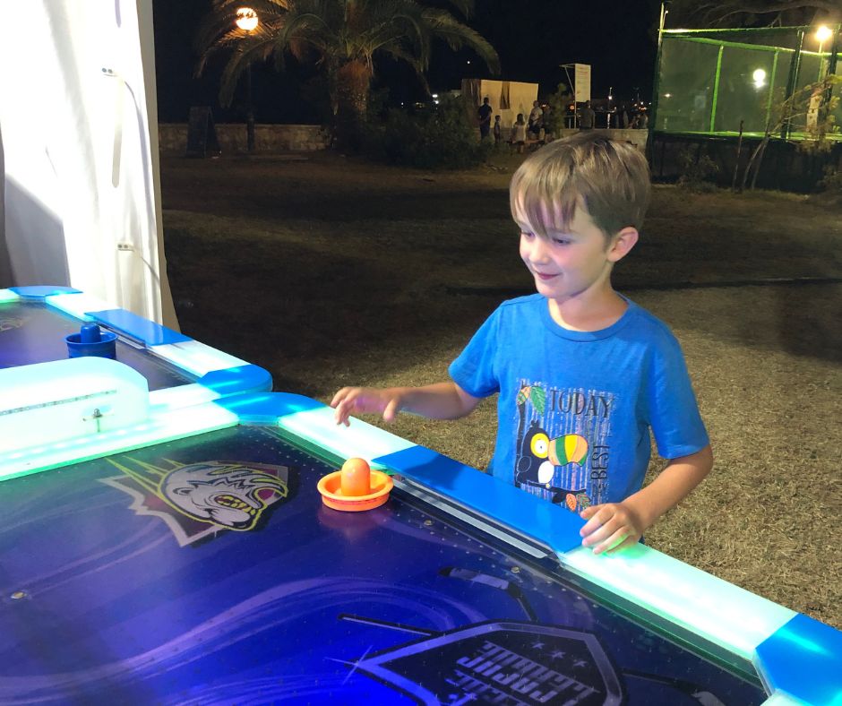 Sawyer playing air hockey at the amusement park in Budva