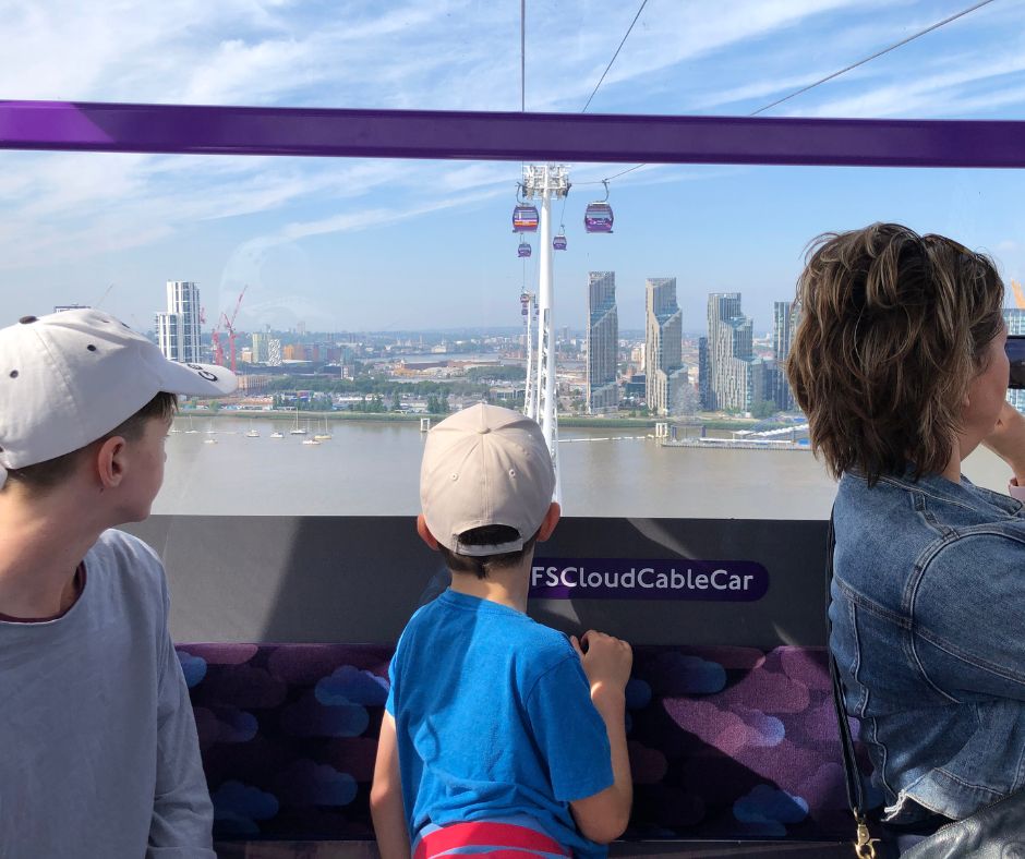 Mum and the boys looking out the Thames Cable car at the London skyline