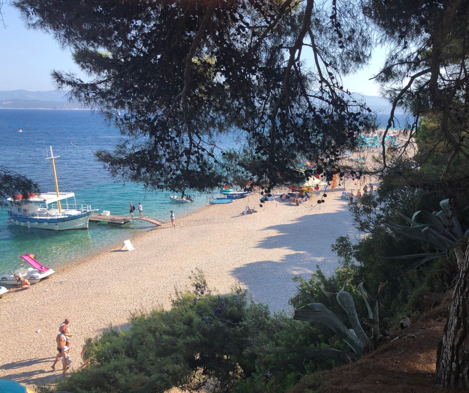 Looking through the trees at Zlatni Rat beach and ferry wharf