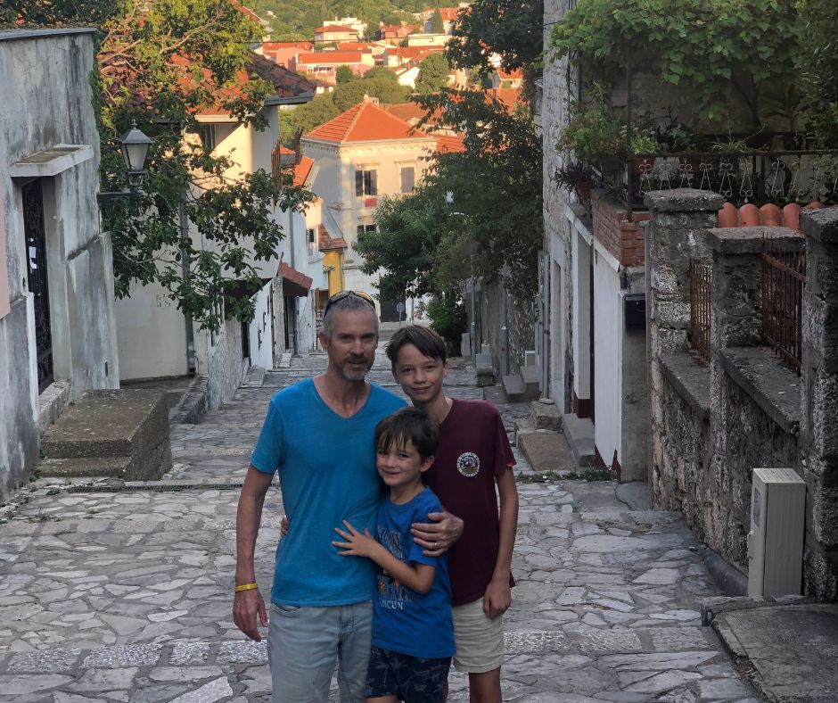 The boys posing for a photo on at the top of the steps looking down to the Old Town of Mostar