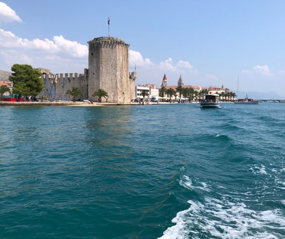 Leaving Trogir on a ferry and looking back at Kamerlengo Castle and the promenade