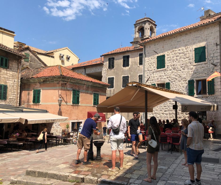 A chance to refill our water bottles from a water fountain in Kotor's Old Town square