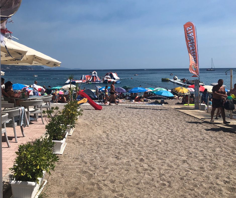 Looking down the beach access with cafes on the side and umbrellas at the front