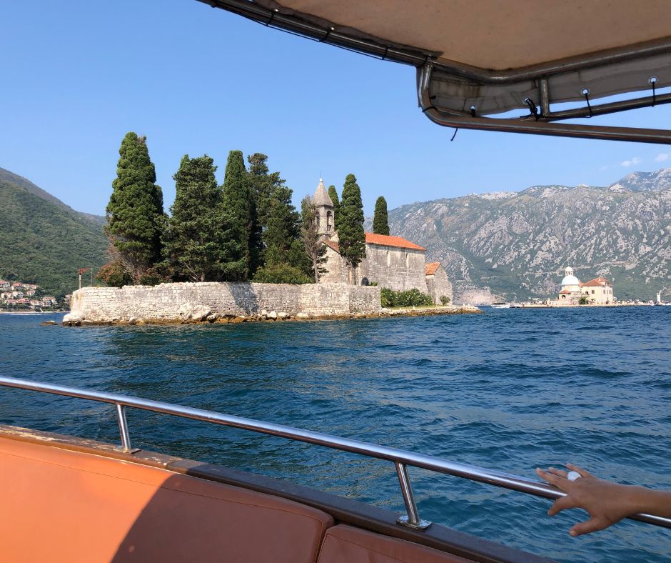 View of Saint George Monastery and the Church of Our Lady of Škrpjela from the boat as we cruise across the Bay of Kotor