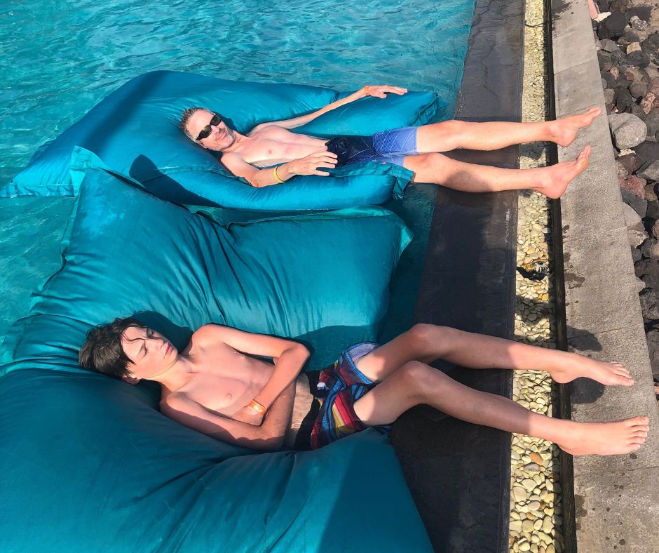 Dad and Lukas relaxing on the inflatable pillows on the pool