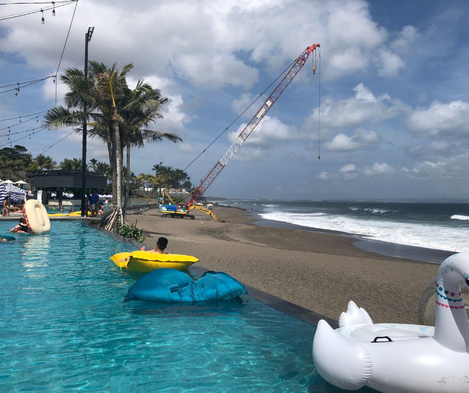 Looking down the infinity pool on the edge of the beach with the ocean in the background