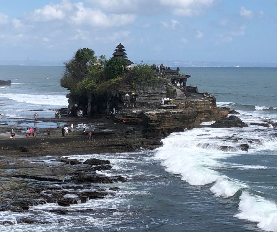 Overlooking tanah lot temple on an island as the waves roll in