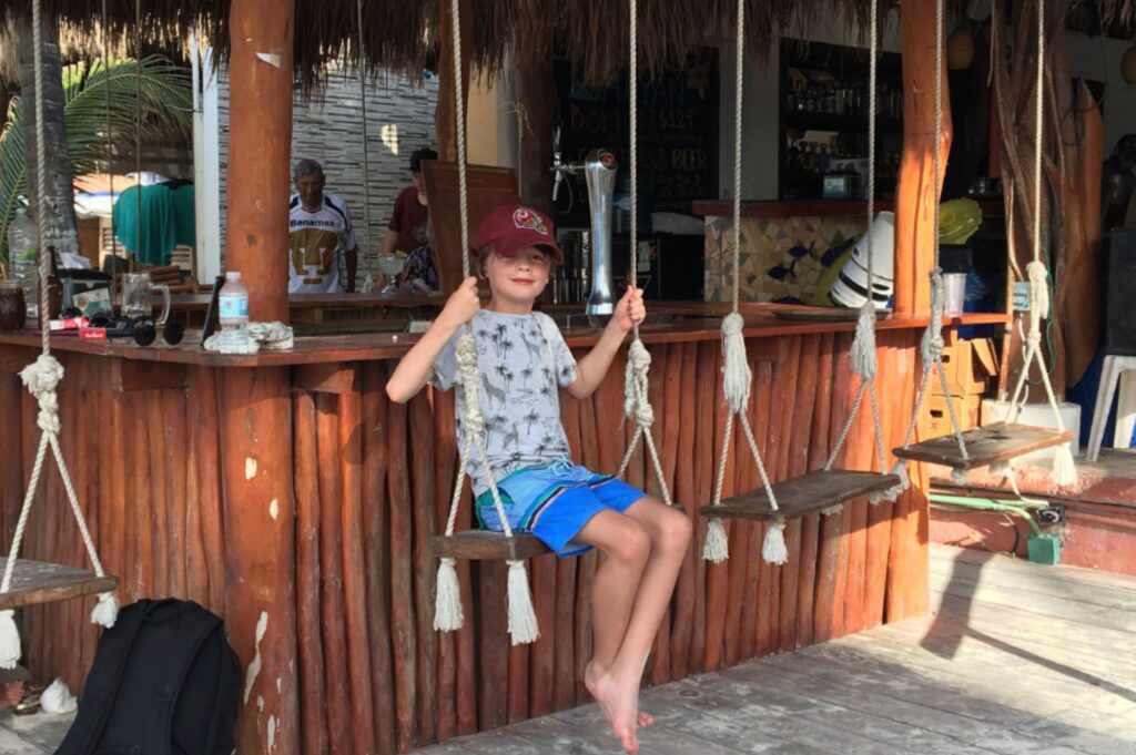 Lukas hanging at the bar on a swing