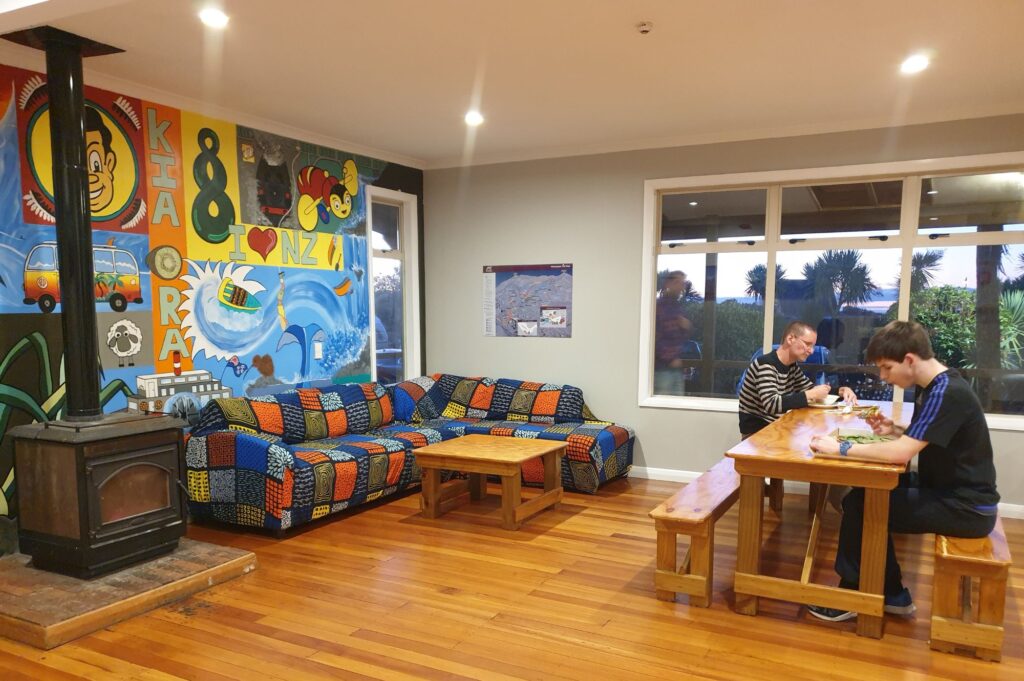 Plateau Lodge shared space , two people sitting at a table eating, sofa in the background